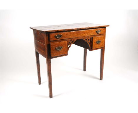 A George III oak side table, the planked top above a long frieze drawer above a central knee-hole flanked by a pair of short 