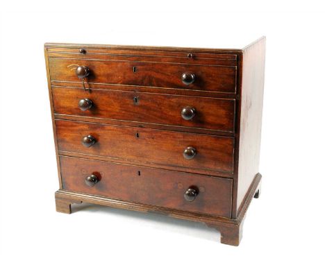 A George III mahogany chest of four graduating long drawers, with a shallow bevelled caddy top above a slender sliding plate 