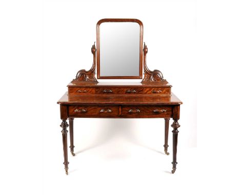 A Victorian flame mahogany veneered dressing table, the rectangular hinged mirror flanked by scrolling acanthus carved mounts