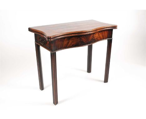 A George III mahogany serpentine card table, the shaped hinged top in flamed veneers opening to reveal a green felt-lined tab