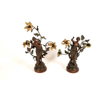 A pair of decorative French spelter three light figural table lamps, 'Muse des Bois' and 'Chant des Pres', each raised on sim