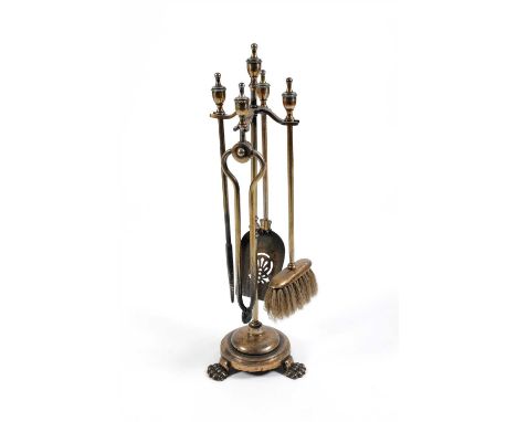 A five piece early 20th century fireside companion set, comprising trowel, poker, tongs, brush and stand, 70 cm high maximum.