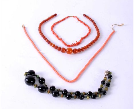 A graduated amber bead necklace, weight approx 15g, together with a stick coral necklace, a simulated coral necklace and a bl