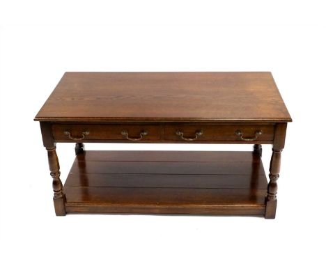 A reproduction oak side table in the George III manner, with a pair of twin-handled frieze drawers raised on turned column su