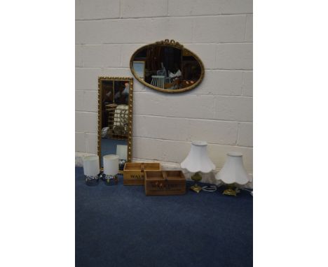 A GILT FRAMED OVAL WALL MIRROR, a similar rectangular wall mirror, two carrying crates, four table lamps and a mantle clock (