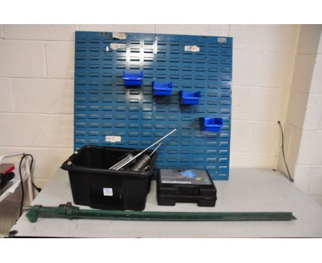A WORKSHOP WALL MOUNTED TOOL RACK with four tubs, a tray of four grease guns, a boxed set of jumper cables and a 120cm long s