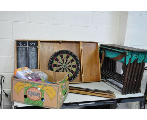 A VINTAGE MILITARY CAMP BED, another camp bed frame, a dartboard in cabinet and a box of cables and light switches (4)