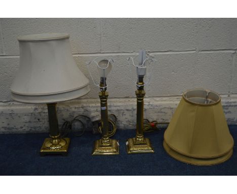 A PAIR OF BRASS CORNITHIAN TABLE LAMPS with gold fabric shades, and another brass table lamp with a fabric shade (3)