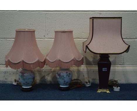 A BURGUNDY CERAMIC TABLE LAMP and a pair of floral ceramic table lamps, all with pink fabric shades (3)