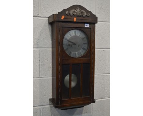 AN EARLY 20TH CENTURY OAK WALL CLOCK (winding key)