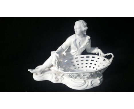 A Meissen style ceramic ornament in the form of a man in traditional costume by a basket 