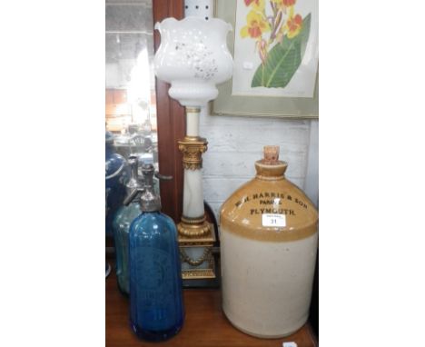 A stoneware jar inscribed 'W.H. Harris & Son parade Plymouth', a blue soda siphon, another similar and a table lamp 