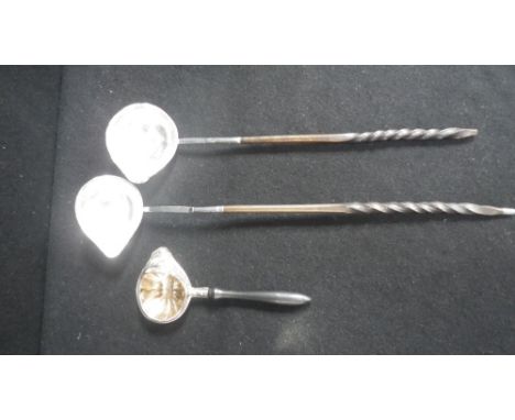 A silver toddy ladle with twisted whalebone handles and two others similar 