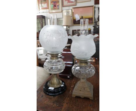 A Victorian oil lamp with cast iron foot and cut glass reservoir and another similar 