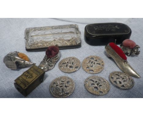 A Continental silver pin-cushion modelled in the form of a lady's shoe, three other pin-cushions, five silver buttons and a p