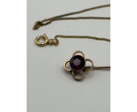A 9ct gold and garnet stick pin and a yellow metal chain (2)