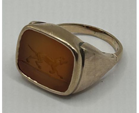 A 9ct gold intaglio signet ring, carved a dogRing size P, stone is orange agate, 10 g all in