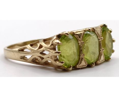 A 9ct gold and peridot three stone ring, ring size M