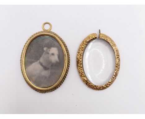 A yellow metal oval locket, inset with a pet portrait of a dog, and a yellow metal and glass pendant (2)