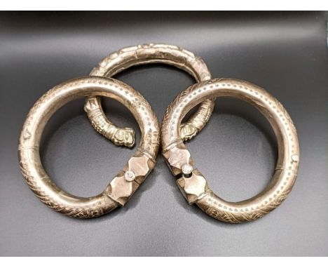 An Eastern silver coloured metal bangle, and two others, 228 g (all in)