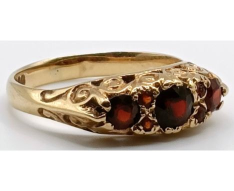 A 9ct gold and garnet three stone ring, ring size O