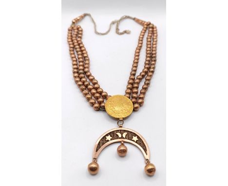 An Eastern Persian gold coin, set into a yellow metal beaded chain, 39.1 g (all in)