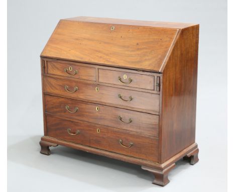 A GEORGE III MAHOGANY SLANT FRONT BUREAU, the moulded rectangular slope opening to reveal a fitted interior above two short o