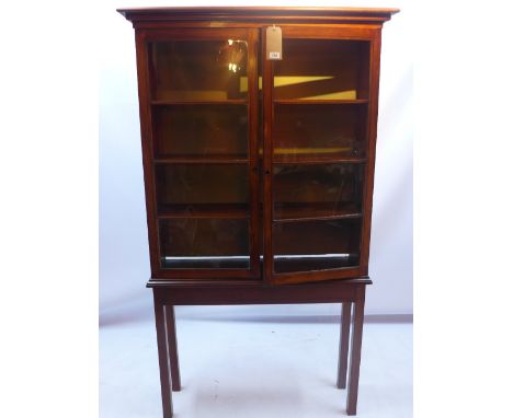 A mahogany glass framed display cabinet raised on square legs 