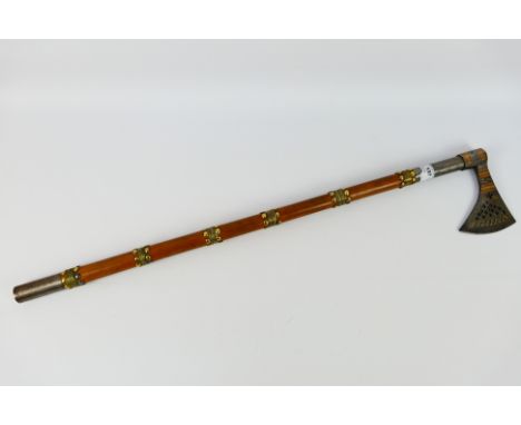 A North Indian axe (Tabarzin) with pierced wedge shaped head on brass mounted wooden haft, approximately 82 cm (l). [W]Note: 