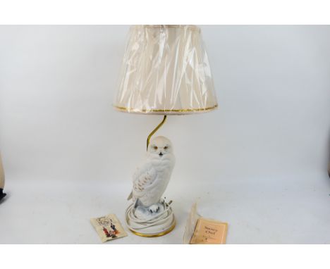 A decorative Franklin Mint table lamp with snowy owl form base designed by Raymond Watson, approximately 45 cm to top of ligh