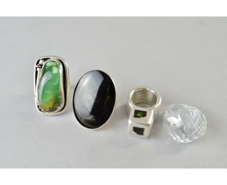 Four modern design rings.  an agate plaque ring, another silver and onyx, a silver cube ring set with moldavite natural glass