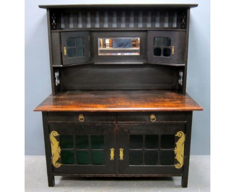 Arts and Crafts dresser in the manner of  M H Baillie Scott. In stained oak with sectioned glazed cabinets, the sides with pi