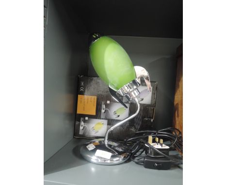 A rocket ship style table top lamp with green body and box