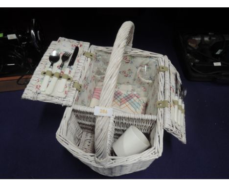 A wicker woven picnic hamper with contents
