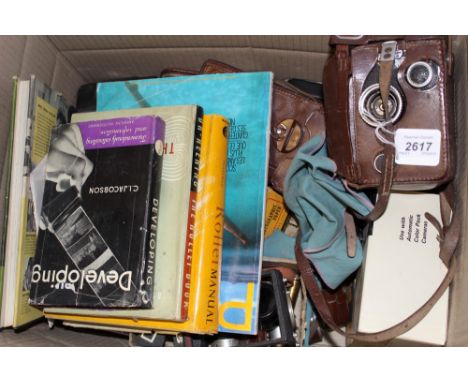 Collection of vintage camera equipment and accessories including Rolleiflex cameras, polaroids, light detectors, books and ot