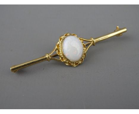 A NINE CARAT GOLD BAR BROOCH with oval centre opal in a twist mount, 1 x 0.8 cms, 3.4 grms gross