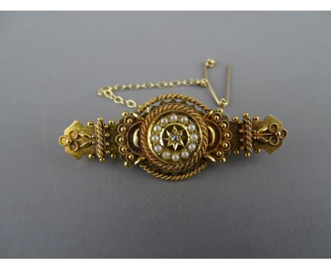 A FINE FIFTEEN CARAT GOLD TARGET STYLE BROOCH with safety chain and pin and having a centre tiny diamond with surrounding see