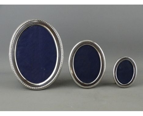 A GRADUATED SET OF THREE OVAL SILVER PORTRAIT FRAMES, 5.5 x 4 cms, 9 x 6 cms and 13.5 x 9.5 cms, Sheffield 1982