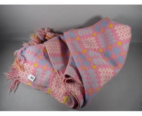 A WELSH WOOLLEN BLANKET, pink, blue and yellow ground with repeating block pattern (repaired patch), 215 x 176 cms approximat