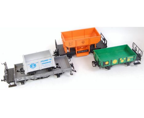3x LGB GI wagons including orange OEG37 hopper, green LG&B open, grey long wheelbase flat truck, and a HLW grey BTO Club 30th