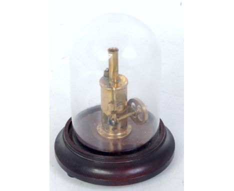 A sweat small vertical steam engine of brass, oscillating single cylinder, 3 inches tall, under glass dome, 5.5 inches overal