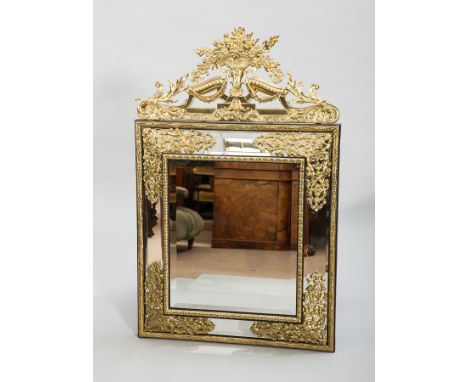 ATTRACTIVE VICTORIAN EBONISED AND BRASS FRAMED UPRIGHT WALL MIRROR
with a cast floral cresting, the central bevelled plate wi
