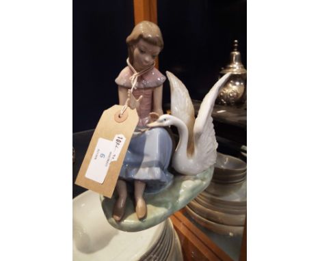A Nao figural group depicting a seated female with swan