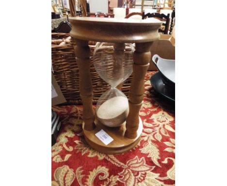 A wicker bottle basket together with a large wooden egg timer