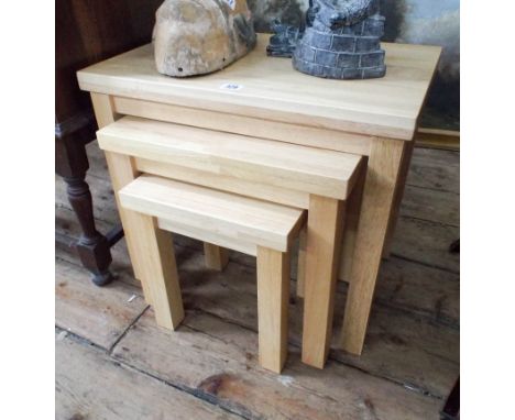 A nest of three light beech coffee tables 