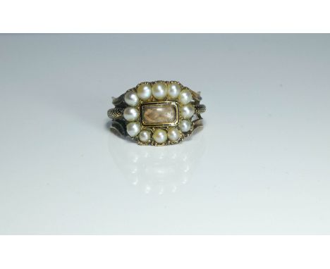 An early 19th century mourning ring set with a rectangular woven hair panel surrounded by split pearls on an unmarked gold se