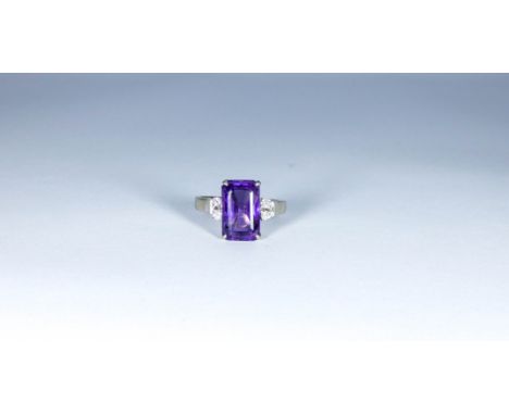 Large amethyst and diamond dress ring set with a large set trap cut amethyst with two brilliant cut diamonds to each side on 