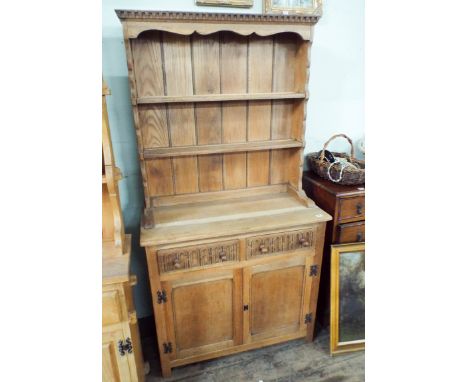 A reproduction light oak Welsh style dresser with drawers and cupboards under 