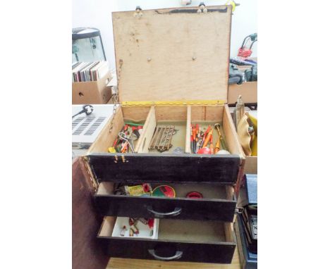 A wooden fishing tackle box with lid and two other drawers with contents and a metal fishing tackle box with contents 