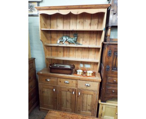 A stripped pine kitchen dresser with shelf back drawers and cupboards under 4' wide